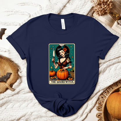 "The Gourd Witch" Tarot Card Halloween Women's T-Shirt featuring a mystical pumpkin-themed witch in deep shades of orange, black, and dark green, perfect for adding an enchanting touch to your Halloween festivities. Available in multiple colors and sizes.  Bella+Canvas 3001 t-shirt in navy. ReadyShirtAim.com