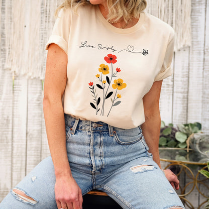 A Boho Scandinavian floral t-shirt with a simple flower design and the caption "Live Simply." Perfect for minimalist souls, garden lovers, and nature enthusiasts. Bella+Canvas 3001 t-shirt in soft cream. ReadyShirtAim.com