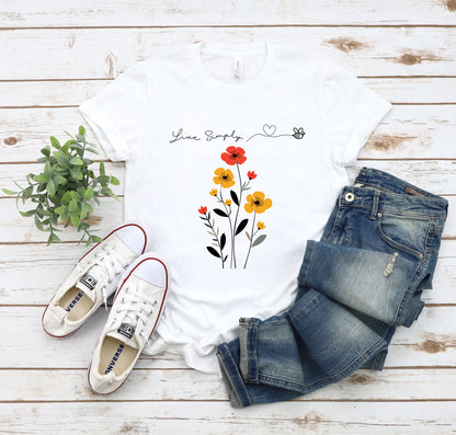 A Boho Scandinavian floral t-shirt with a simple flower design and the caption "Live Simply." Perfect for minimalist souls, garden lovers, and nature enthusiasts. Bella+Canvas 3001 t-shirt in white. ReadyShirtAim.com