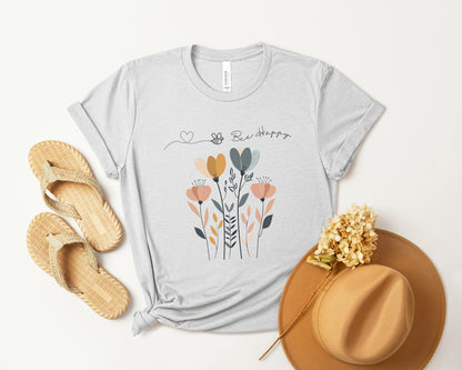 A Boho Scandinavian floral t-shirt with a simple flower design and the caption "Bee Happy." Perfect for spreading positive vibes, garden lovers, and nature enthusiasts. Bella+Canvas 3001 t-shirt in ash. ReadyShirtAim.com